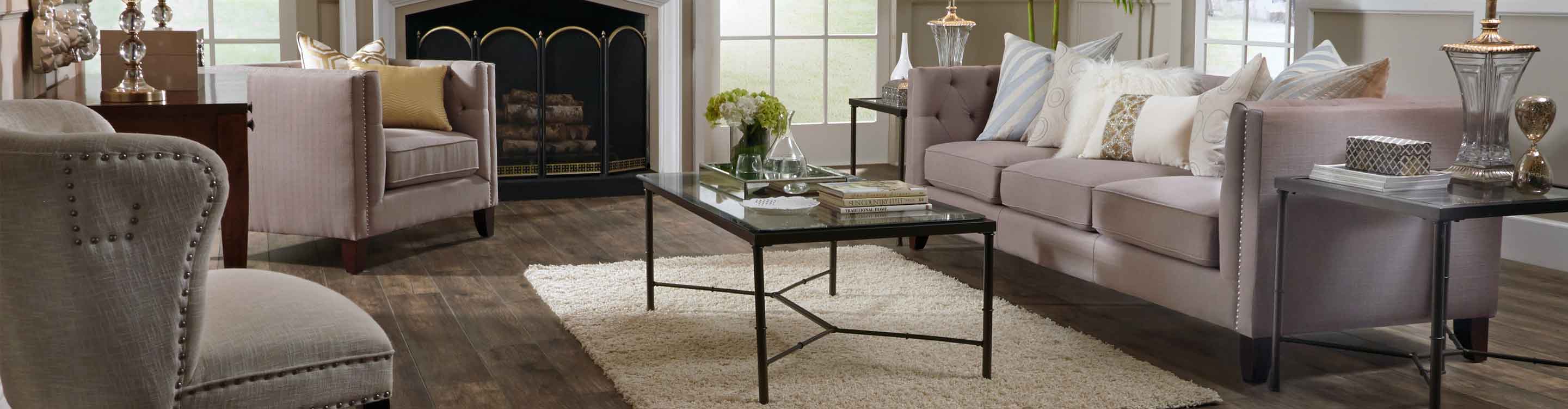wood look laminate flooring in living room with grey couches